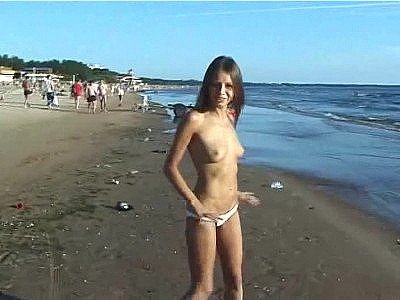 Naked young girl riding a horse at the beach turns heads